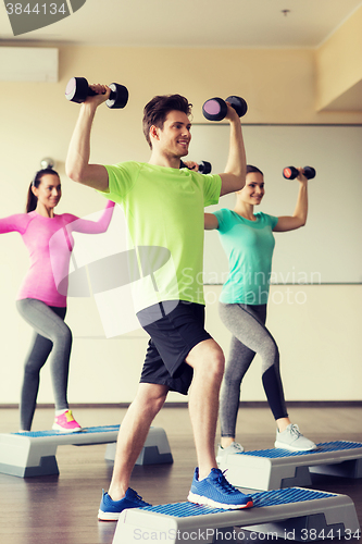 Image of group of people with dumbbells and steppers