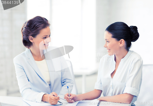 Image of two businesswomen having discussion in office