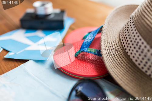 Image of close up of travel tickets, flip-flops and hat