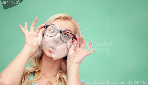 Image of happy young woman in glasses making fish face