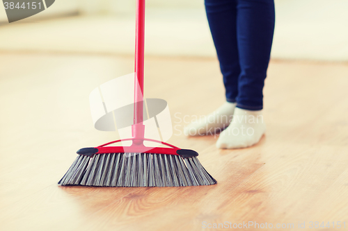 Image of close up of woman legs with broom sweeping floor