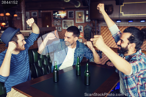 Image of happy male friends drinking beer at bar or pub