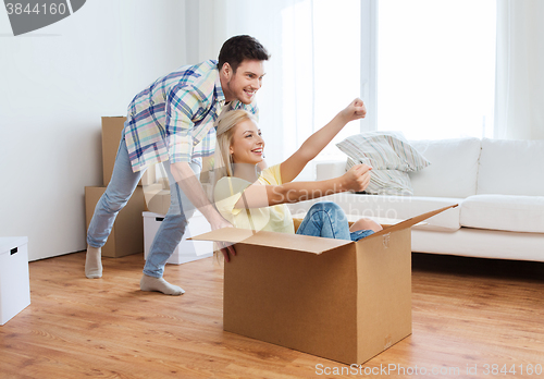 Image of happy couple having fun with boxes at new home