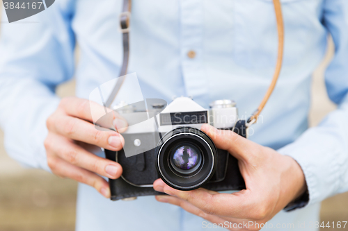 Image of close up of hipster man with film camera in city