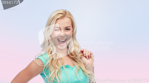 Image of smiling young woman holding her strand of hair