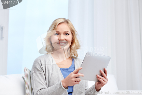 Image of happy middle aged woman with tablet pc at home