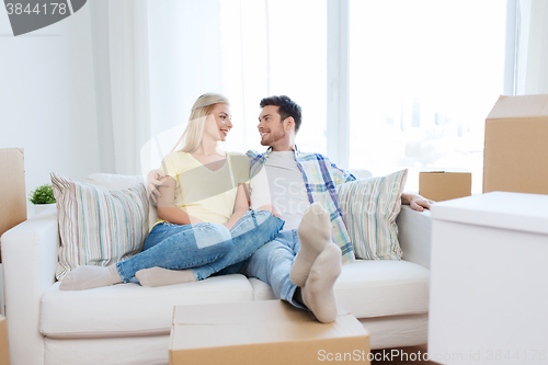 Image of happy couple with big cardboard boxes at new home