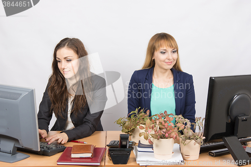 Image of Two office employee, one of which workplace forced by plants