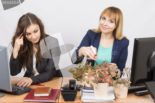 Image of  Office employee considers crazy colleague - a lover of flowers