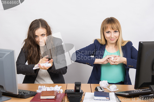 Image of Employees of office paper crumpling up to something