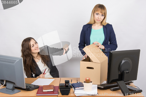 Image of Office woman with a humiliating gesture unsettled the dismissed colleague