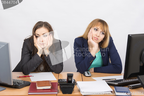 Image of  Two young office worker tired of sitting in front of computers