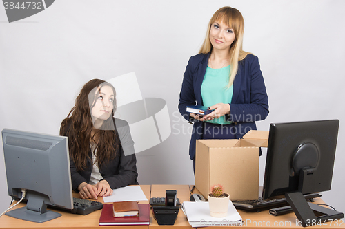 Image of Girl in office standing with a smile in front of a box about colleagues