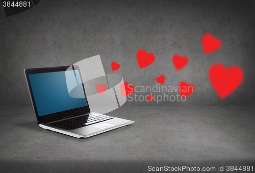 Image of laptop with blank screen and red hearts