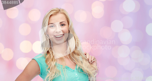 Image of smiling young woman holding her strand of hair