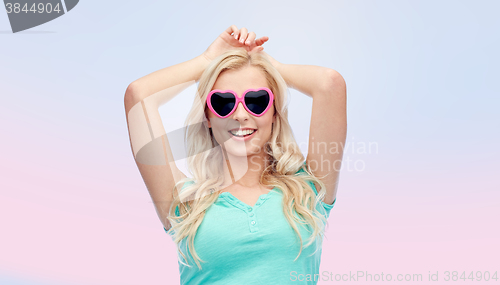 Image of happy young woman in heart shape sunglasses