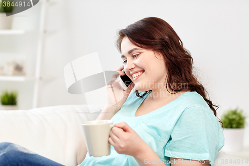 Image of plus size woman calling on smartphone at home