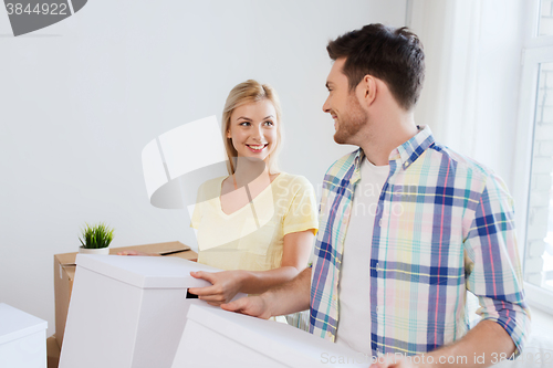 Image of smiling couple with big boxes moving to new home