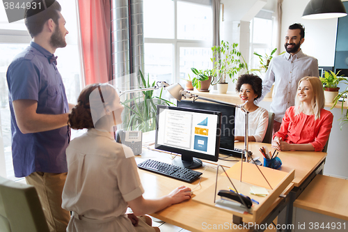 Image of happy creative team talking in office