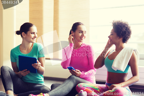 Image of happy women listening to music in gym