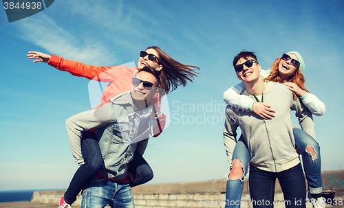 Image of happy teenage friends having fun outdoors