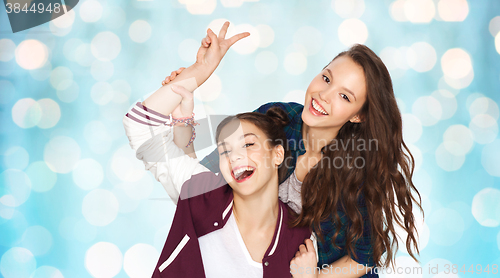 Image of happy pretty teenage girls showing peace hand sign