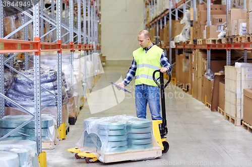 Image of man with loader and clipboard at warehouse