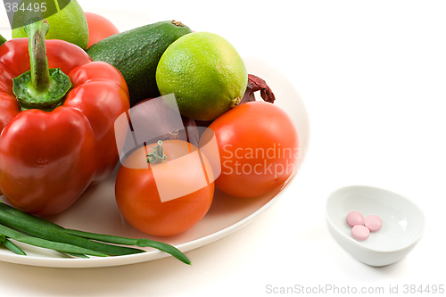 Image of fresh vegetables against vitimin pill