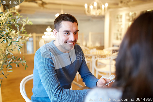 Image of happy couple talking at cafe or restaurant