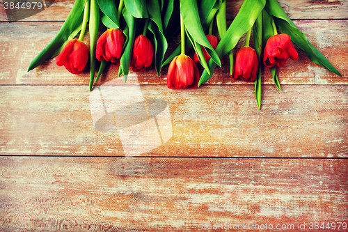 Image of close up of red tulips on wooden background