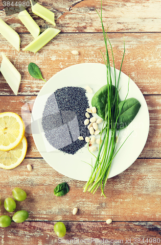 Image of close up of peanut, greens and poppy or chia seeds