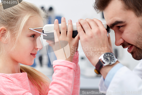 Image of optician with pupilometer and patient at eye clinic