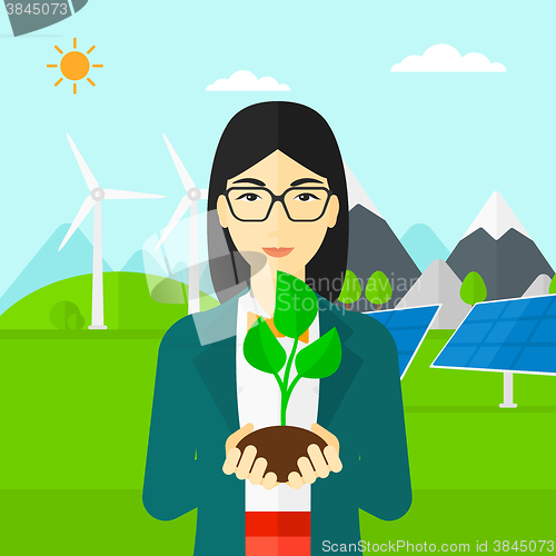 Image of Woman holding plant.