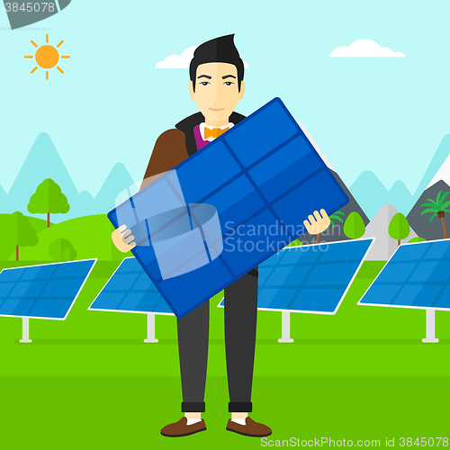 Image of Man holding solar panel.