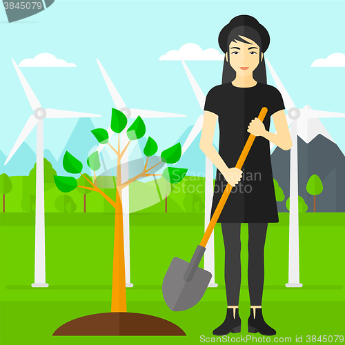 Image of Woman plants tree.