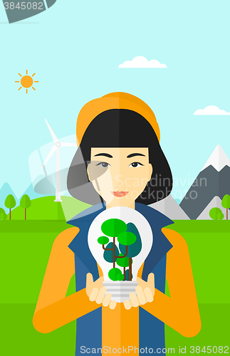 Image of Woman with lightbulb and trees inside.