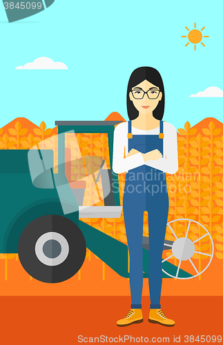 Image of Woman standing with combine on background.