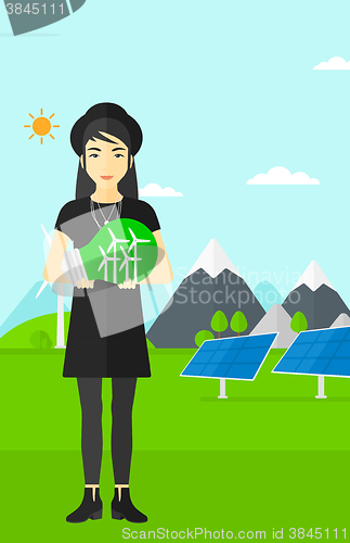 Image of Woman holding lightbulb with windmills inside.