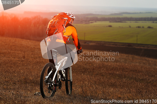 Image of Man cyclist with backpack riding the bicycle