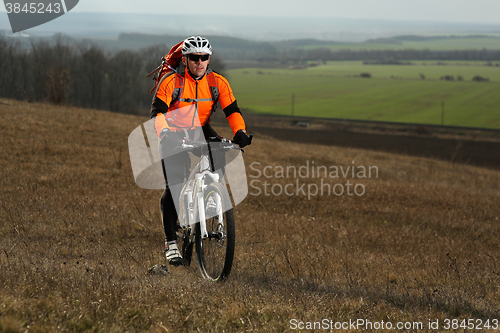 Image of Man cyclist with backpack riding the bicycle