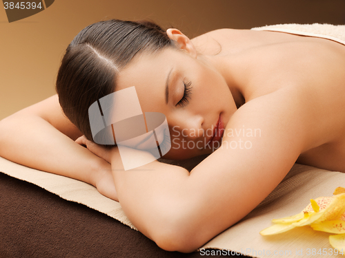 Image of woman in spa salon lying on the massage desk