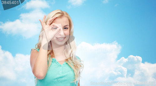 Image of young woman making ok hand gesture