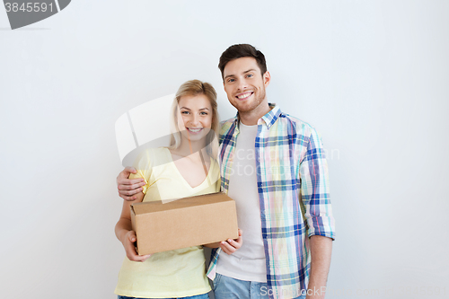 Image of smiling couple with box moving to new home