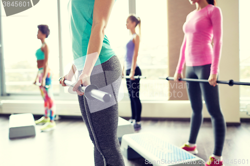 Image of close up of women exercising with bars in gym