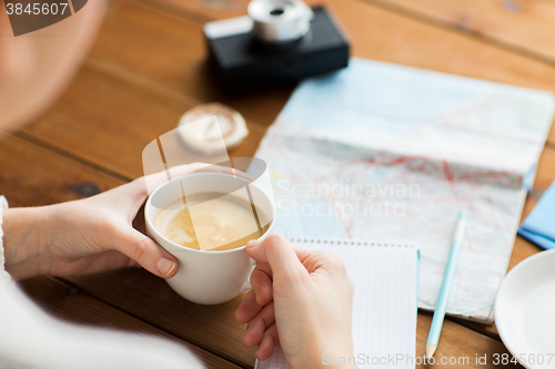 Image of close up of hands with coffee cup and travel stuff