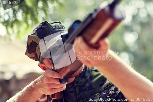 Image of soldier or hunter shooting with gun in forest