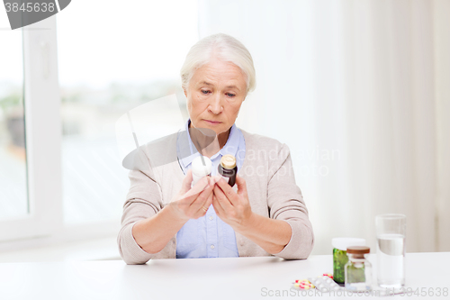 Image of senior woman with medicine jars at home