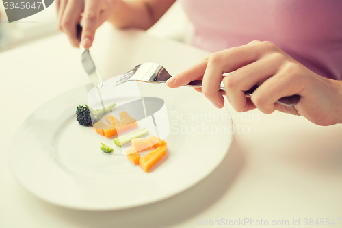 Image of close up of woman hands eating vegetables