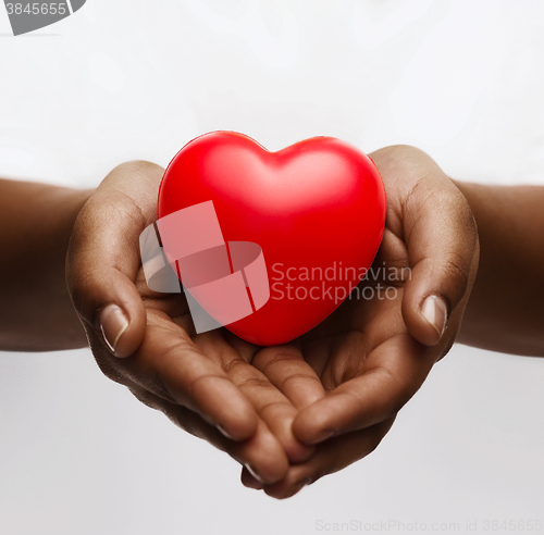 Image of female hands with small red heart
