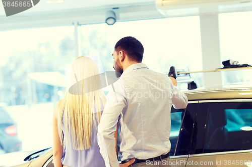 Image of couple buying car in auto show or salon
